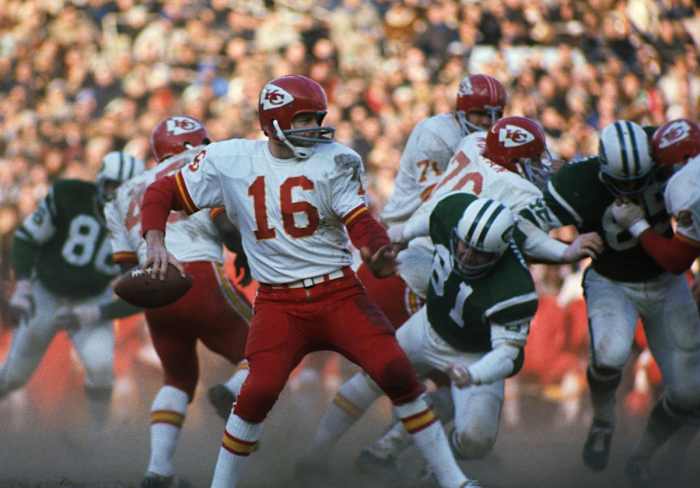 Len Dawson brings his arm back to throw the football
